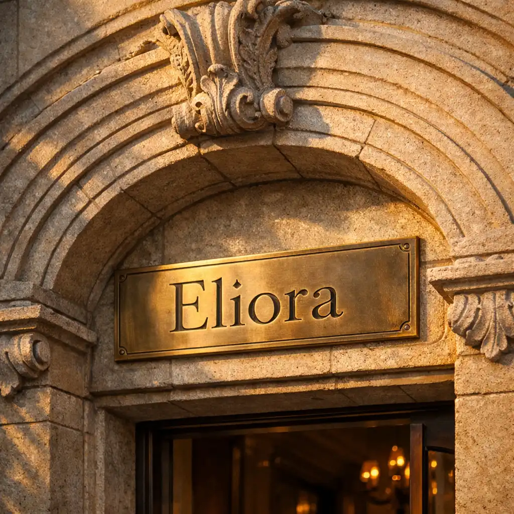 Carved stone archway with brass Eliora plaque in warm evening light